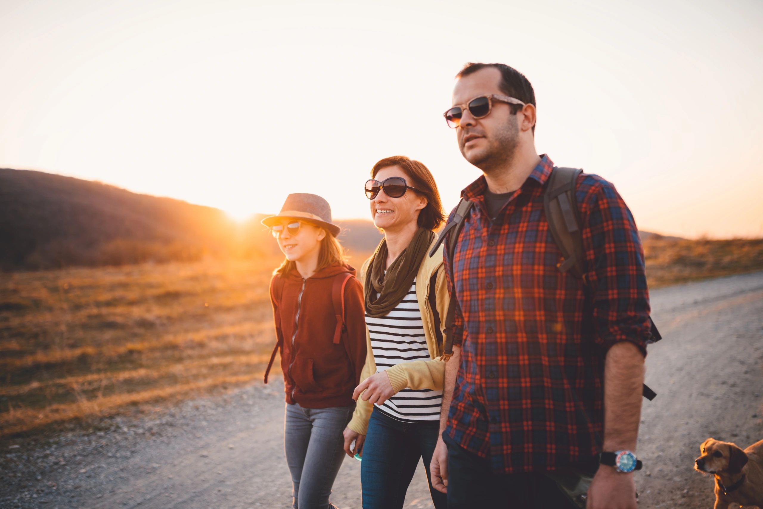 Family hiking together on a trail at sunset