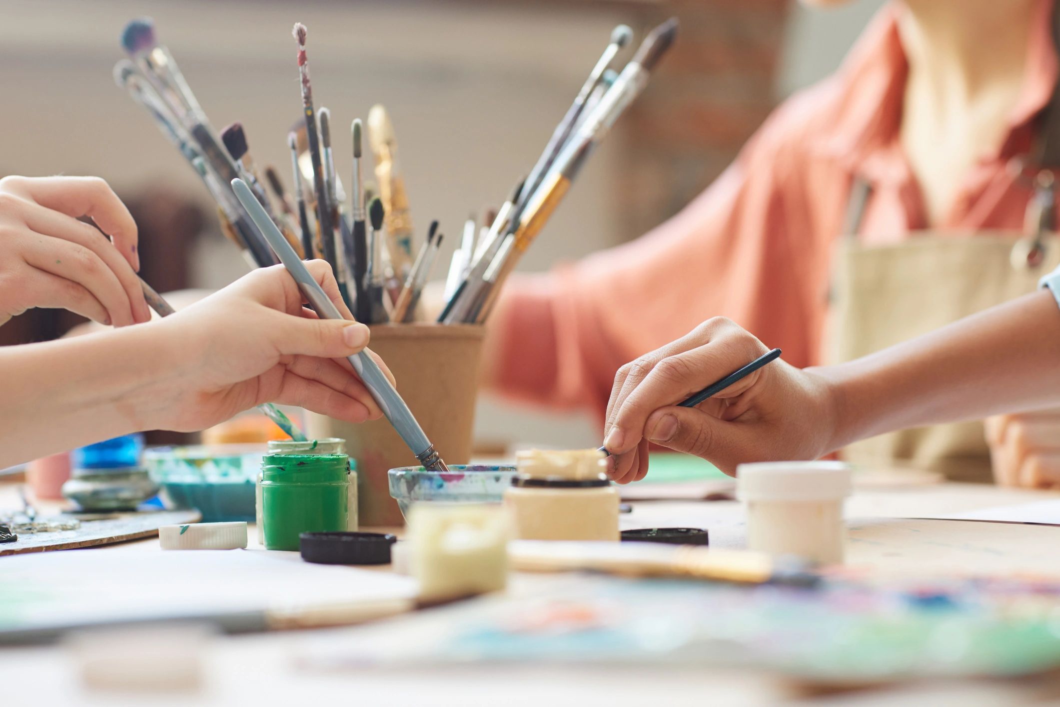 Children using watercolor paints at a table