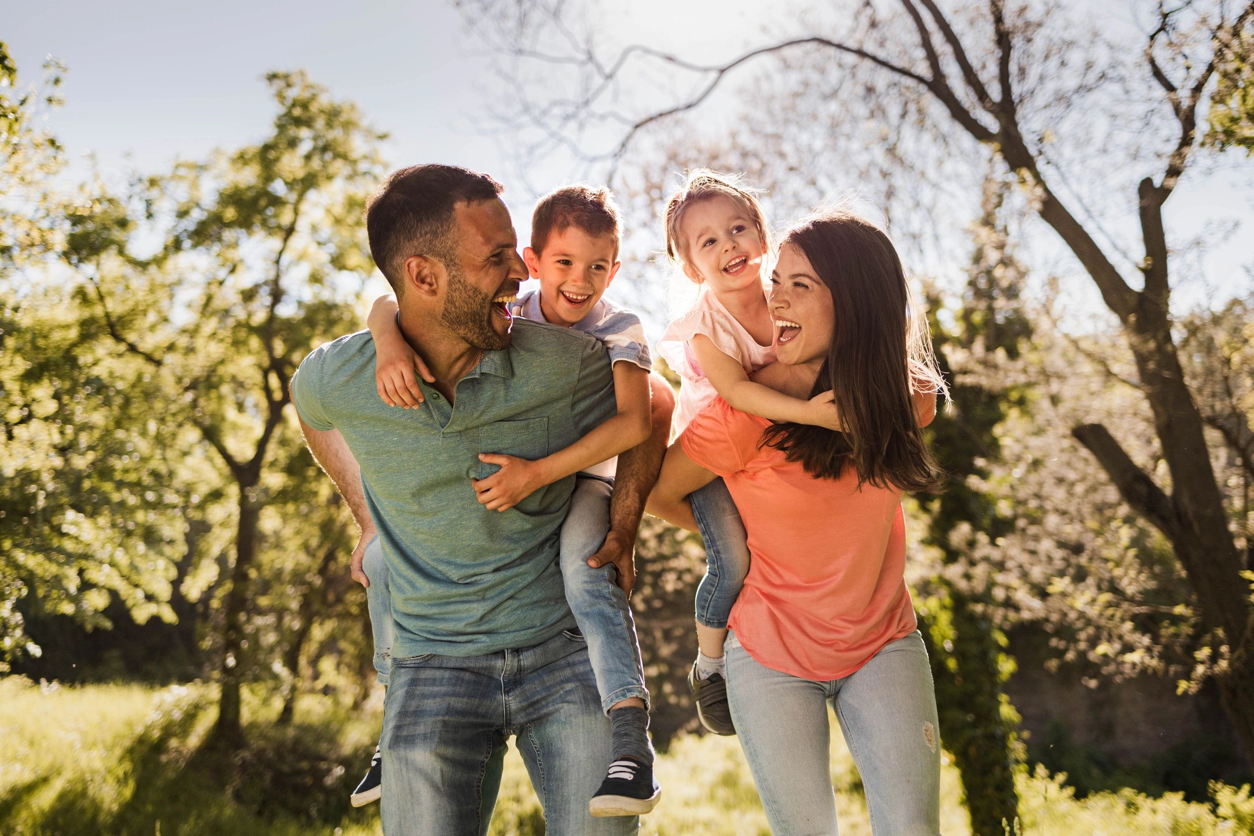 Parents playing with kids outdoors on a nature path
