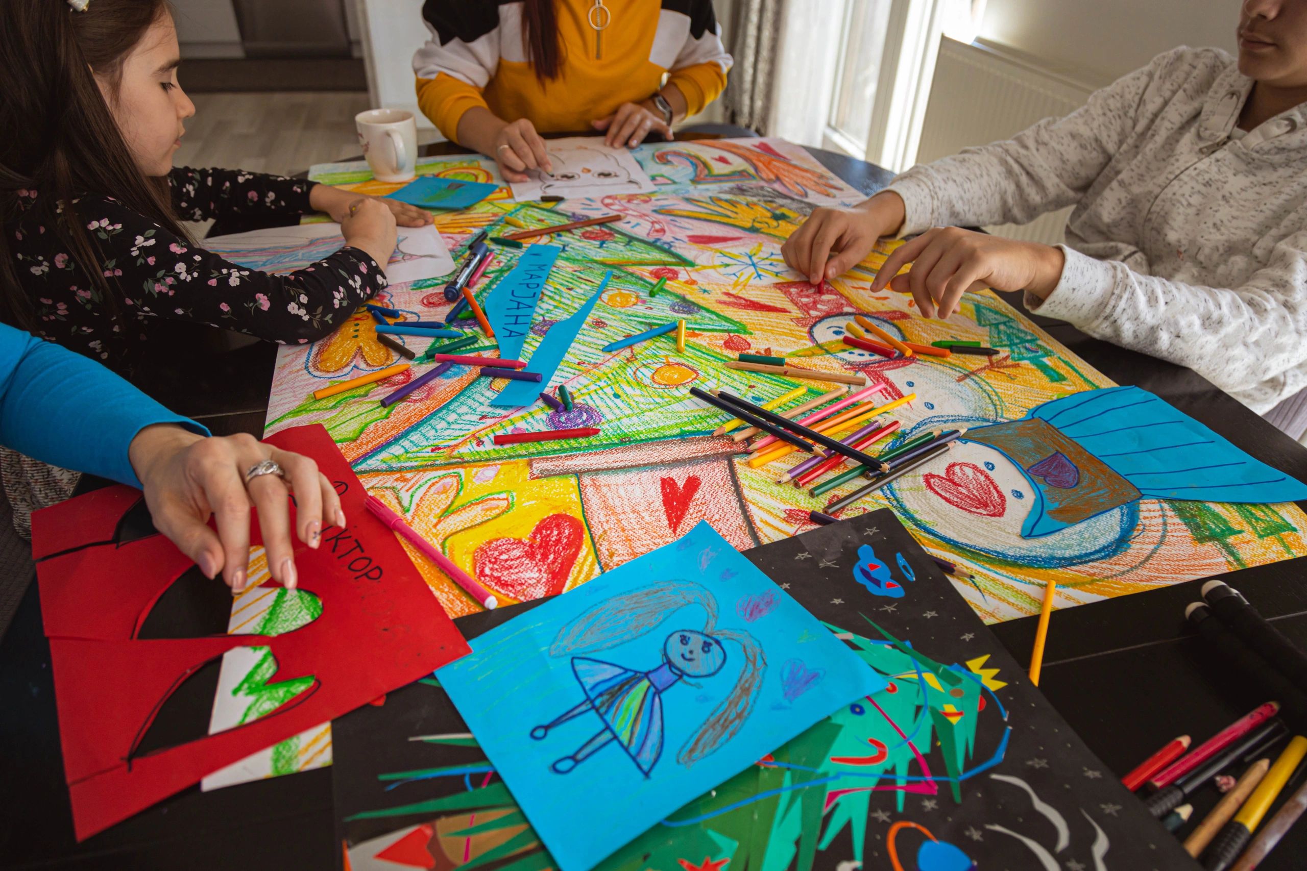 Family drawing and making a holiday poster together