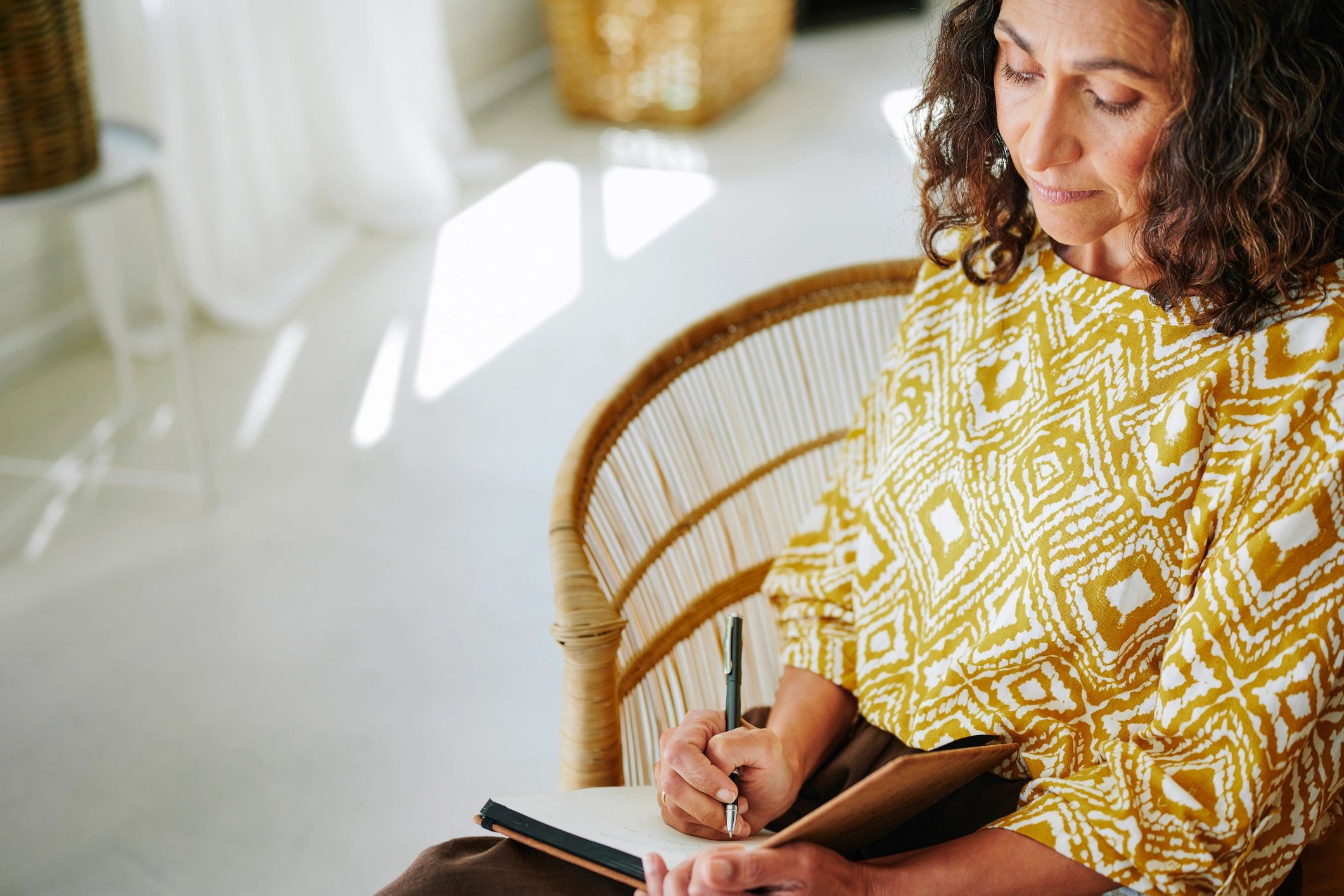 Woman journaling at home with a cup of coffee
