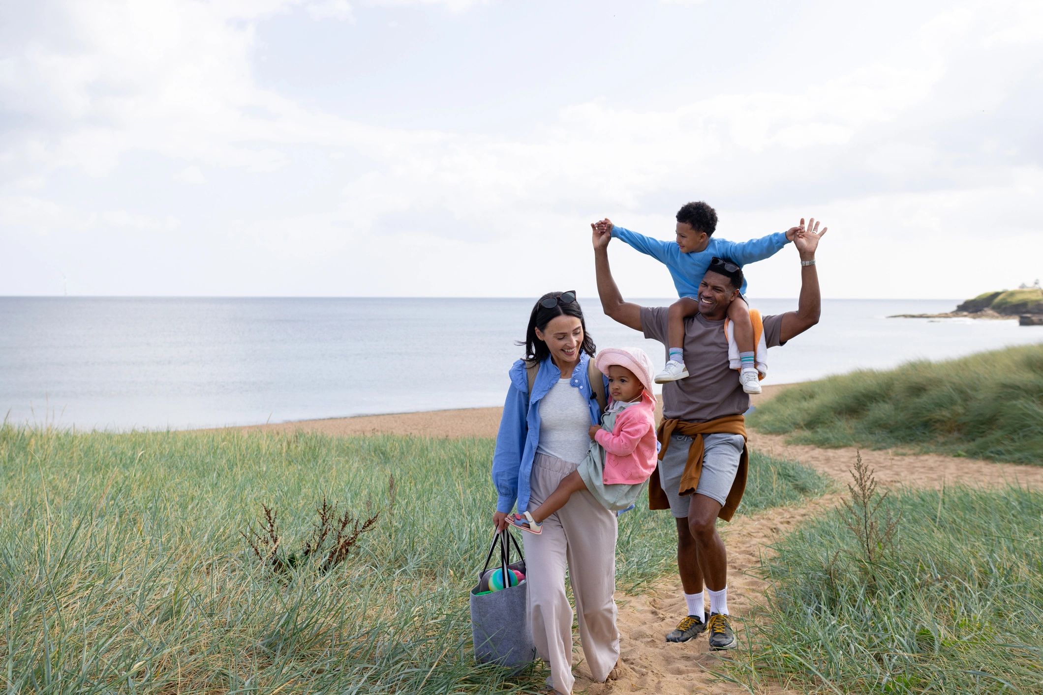 Family walking along a beach path near the ocean