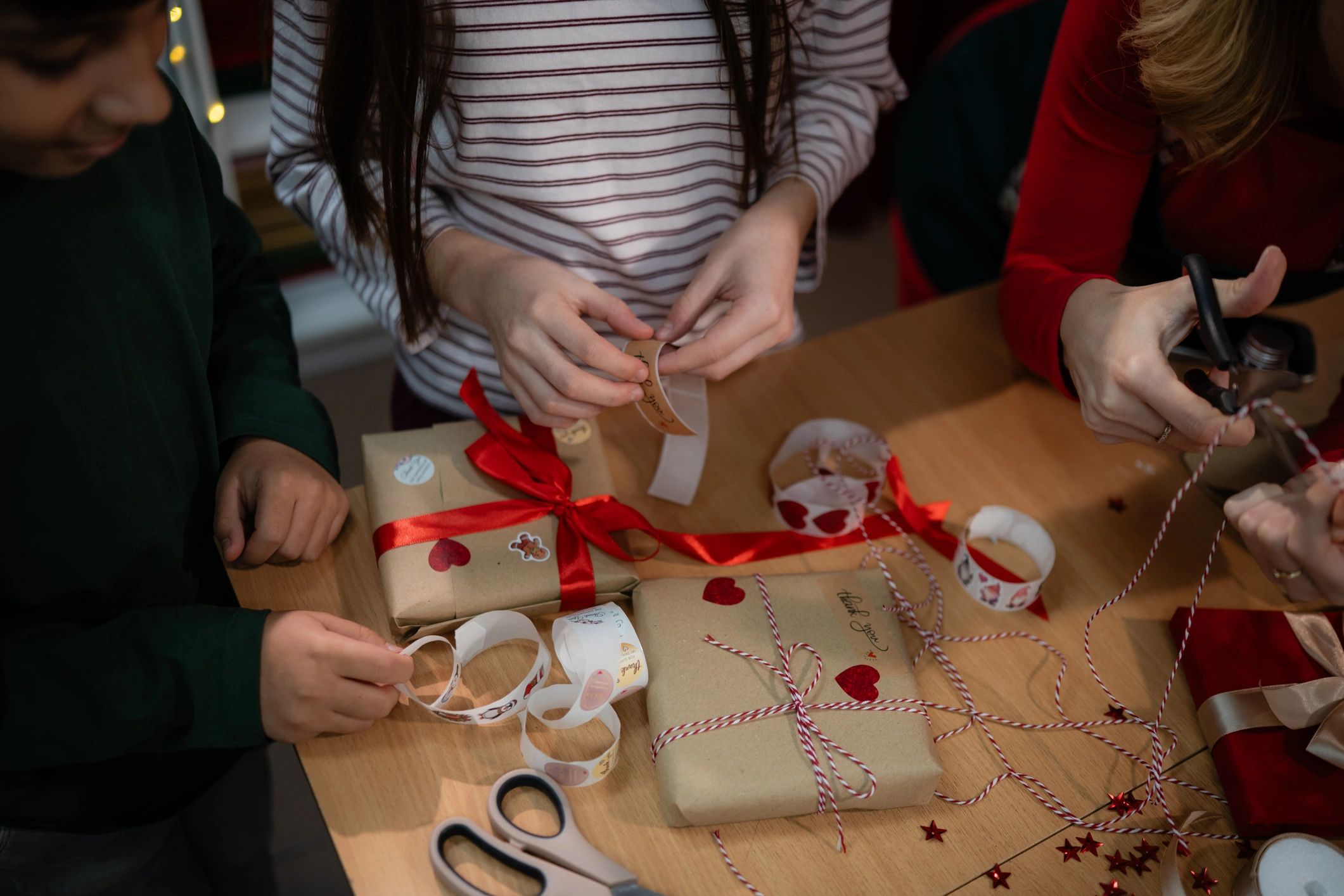 Hands wrapping gifts with paper and ribbon